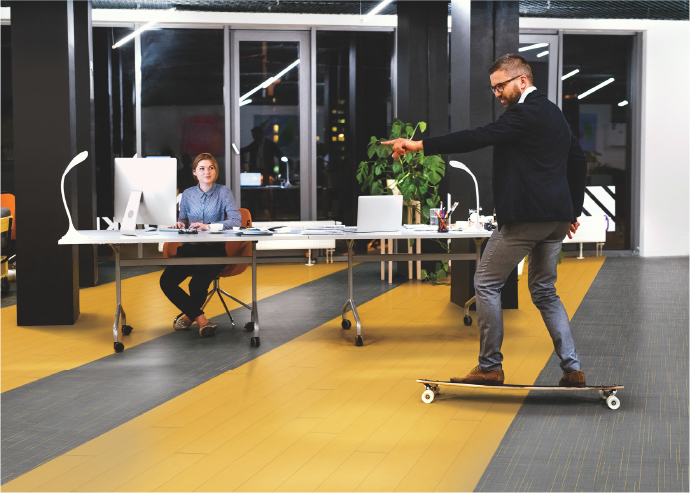 man skateboarding on colored floor in office